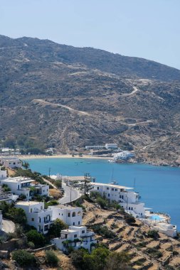 Ios, Yunanistan - 26 Mayıs 2021: Beyazyıkanmış otellerin manzarası ve Yunanistan 'daki ünlü Mylopotas plajına giden yol
