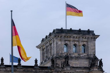 Berlin, Almanya - 18 Nisan 2023: Reichstag 'ın tepesi, Berlin Almanya' daki Alman parlamentosu, AB bayrağı ve Alman bayrağı