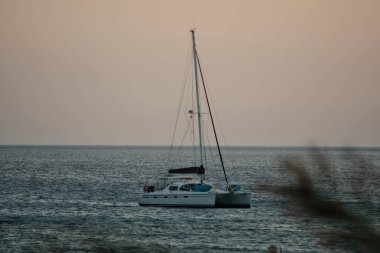 Ios, Yunanistan - 24 Mayıs 2021: Yunanistan 'daki Mylopotas plajında küçük bir yelkenli manzarası