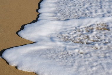 Yunanistan 'da güzel kumlu bir plaja ve beyaz köpüklü dalgalara yakın