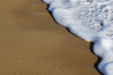 Yunanistan 'da güzel kumlu bir plaja ve beyaz köpüklü dalgalara yakın