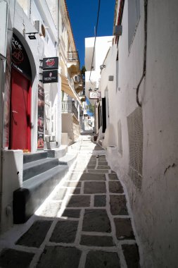 Ios, Yunanistan - 21 Mayıs 2021: Yunanistan 'ın pitoresk adasında barları ve dükkanları olan tipik bir sokak manzarası