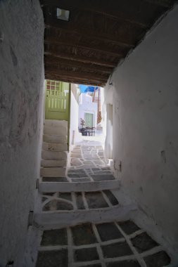 Ios, Yunanistan - 21 Mayıs 2021: Yunanistan 'ın pitoresk adasında barları ve dükkanları olan tipik bir sokak manzarası