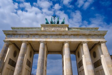 Berlin, Almanya - 18 Nisan 2023: Berlin 'deki Brandenburg Kapısı veya Brandenburger Tor manzarası ve mavi bir gökyüzü