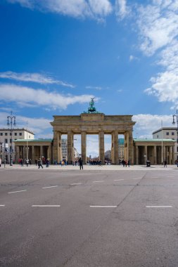 Berlin, Almanya - 18 Nisan 2023: Berlin 'deki Brandenburg Kapısı veya Brandenburger Tor manzarası ve mavi bir gökyüzü