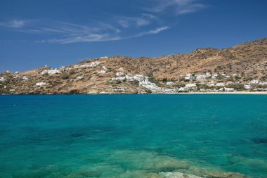 Ios, Yunanistan - 18 Mayıs 2021: Ios siklades Yunanistan 'daki popüler Mylopotas plajında ve güzel mavi gökyüzünde kiralanmak üzere beyazlatılmış otel ve odalar