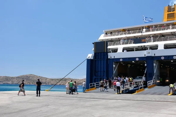 Ios, Yunanistan - 18 Mayıs 2021: Yunanistan 'ın Ios adasının limanında turistler, motorsikletler ve arabaların gidip geldiği bir feribot görüntüsü