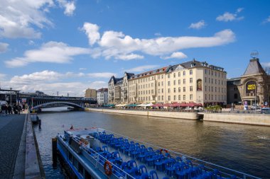 Berlin, Almanya - 18 Nisan 2023: Berlin 'de Spree Nehri' nde bir turistik gezi teknesi ve arka planda çeşitli konut binaları