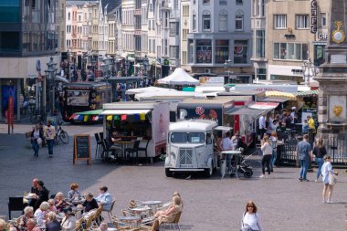 Bonn, Almanya - 22 Mayıs 2023: Bonn Almanya 'daki pazar meydanının çeşitli gıda kamyonları, kafeler, dükkanlar, restoranlar ve günün tadını çıkaran insanlarla manzarası
