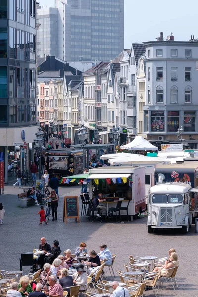 Bonn, Almanya - 22 Mayıs 2023: Bonn Almanya 'daki pazar meydanının çeşitli gıda kamyonları, kafeler, dükkanlar, restoranlar ve günün tadını çıkaran insanlarla manzarası