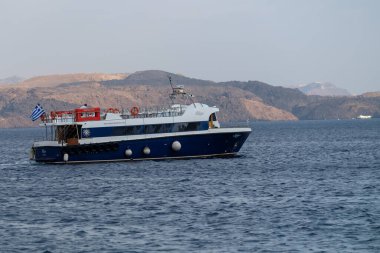 Santorini, Yunanistan - 7 Eylül 2023: Santorini Yunanistan 'da küçük bir tekne gezisi ve arka plandaki yanardağ