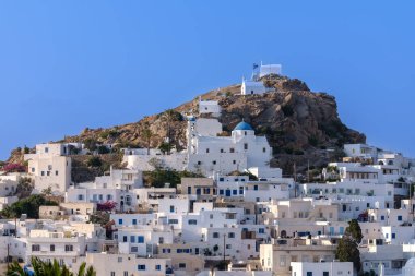 Resimli ve beyazlatılmış Yunanistan adasının panoramik manzarası ve arka planda mavi bir gökyüzü