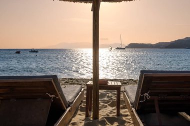 Yunanistan 'ın Mylopotas plajında iki güneşli yatak ve bir güneş şemsiyesi