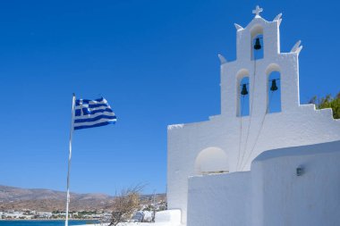 Agia Irini 'nin beyazlatılmış kilisesi Yunan ulusal bayrağının yanında.