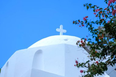 Yunanistan 'daki güzel, bembeyaz bir ortodoks kilisesi ve arka planda mavi bir gökyüzü.