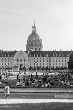 Paris, Fransa - 8 Ekim 2023: Hotel des Invalides 'in önündeki yeşil parkta küçük gruplar halinde oturan gençlerin görüntüsü