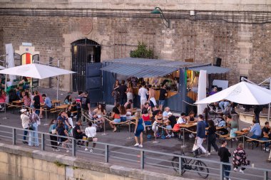 Paris, Fransa - 8 Ekim 2023: Paris, Fransa 'da Seine nehrinin yanındaki yaya caddesinde kalabalık bir açık hava bar restoranı manzarası