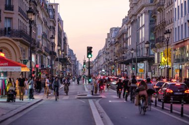 Paris, Fransa - 8 Ekim 2023: Günbatımında Paris 'in ticari caddesi olan Rivoli sokağında yayalar, bisikletler ve arabaların görüntüsü