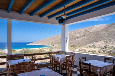 Agia Theodoti, Yunanistan - 14 Eylül 2023 - Yunanistan 'daki Agia Theodoti Sahili üzerinde nefes kesici manzaralı bir restoranın sandalye ve masalarının manzarası