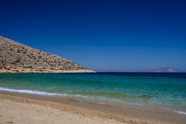 Ios Cyclades Yunanistan 'daki Agia Theodoti' nin kumlu ve turkuaz rüya plajının panoramik manzarası