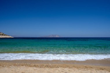 Ios Cyclades Yunanistan 'daki Agia Theodoti' nin kumlu ve turkuaz rüya plajının panoramik manzarası