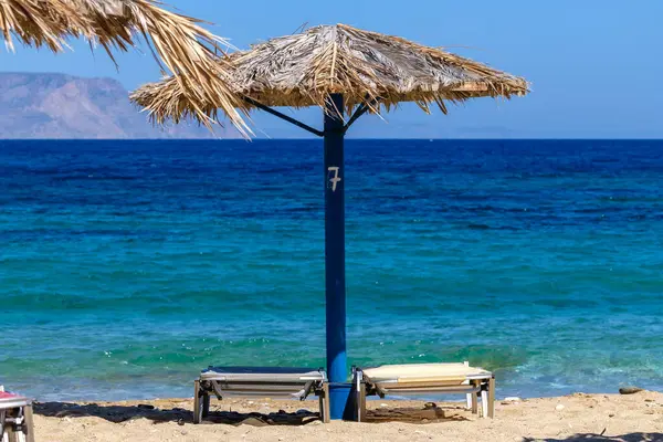Ios 그리스의 Agia Theodoti의 놀라운 해변에서 침대와 우산의 로열티 프리 스톡 사진