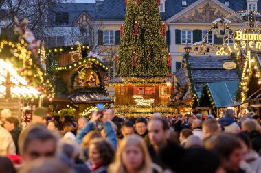 Bonn, Almanya - 16 Aralık 2023: Bonn Almanya 'daki geleneksel ve pitoresk Noel Pazarı' nda insanlar yürüyor