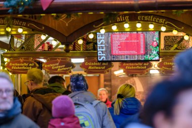 Bonn, Almanya - 16 Aralık 2023: Bonn Almanya 'daki Noel pazarında geleneksel Alman sosisleri satın alan insanların görüntüsü