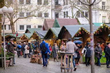 Bonn, Almanya - 23 Aralık 2023: Bonn Almanya 'daki geleneksel ve resimli Noel Pazarı' nda insanlar yürüyor