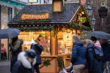Bonn, Almanya - 17 Aralık 2023: Bonn Almanya 'daki Noel Pazarı' nda Churros ve diğer şekerleri satan küçük bir gıda standının görüntüsü