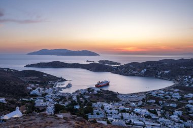 Ios, Yunanistan - 14 Eylül 2023: Güneş çarpıcı bir şekilde batarken Yunanistan 'ın Ios limanının manzaralı manzarası