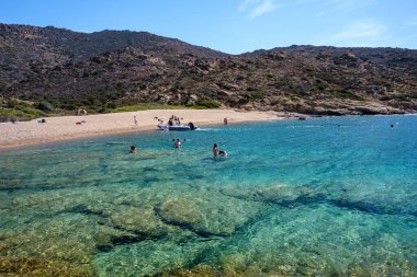 Ios, Yunanistan - 15 Eylül 2023: Sürat tekneleriyle gelen ve Yunanistan 'ın en muhteşem turkuaz plajlarından biri olan Pikri Nero' nun keyfini çıkaran turistleri görmek
