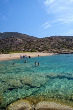 Ios, Yunanistan - 15 Eylül 2023: Sürat tekneleriyle gelen ve Yunanistan 'ın en muhteşem turkuaz plajlarından biri olan Pikri Nero' nun keyfini çıkaran turistleri görmek