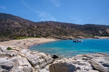 Ios, Yunanistan - 15 Eylül 2023: Sürat tekneleriyle gelen ve Yunanistan 'ın en muhteşem turkuaz plajlarından biri olan Pikri Nero' nun keyfini çıkaran turistleri görmek