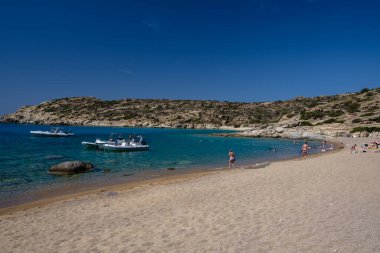 Ios, Yunanistan - 15 Eylül 2023: Ios 'taki Pikri Nero' nun kumlu ve turkuaz plajının tadını çıkaran genç turistleri görmek
