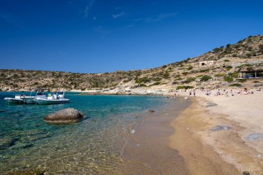 Ios, Yunanistan - 15 Eylül 2023: Sürat tekneleriyle gelen ve Yunanistan 'ın en muhteşem turkuaz plajlarından biri olan Pikri Nero' nun keyfini çıkaran turistleri görmek