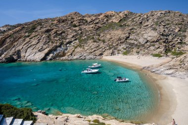 Ios, Yunanistan - 15 Eylül 2023: Yunanistan 'daki Trablus adasındaki nefes kesen turkuaz plajda sürat tekneleri gezisi manzarası