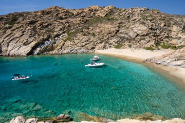 Ios, Greece - September 15, 2023 : View of excursion speed boats at the  breathtaking turquoise beach of Tripiti on the island of Ios Greece clipart