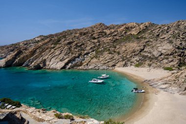 Ios, Yunanistan - 15 Eylül 2023: Yunanistan 'daki Trablus adasındaki nefes kesen turkuaz plajda sürat tekneleri gezisi manzarası