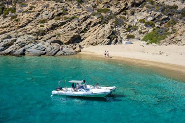 Ios, Yunanistan - 15 Eylül 2023: Yunanistan 'daki Trablus adasındaki nefes kesen turkuaz plajda sürat tekneleri gezisi manzarası