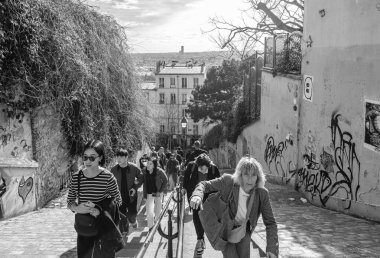 Paris, Fransa - 17 Şubat 2024: Paris Fransa 'nın Montmartre bölgesindeki pitoresk merdivenlerde yürüyen turistlerin görüntüsü