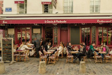 Paris, Fransa - 17 Şubat 2024: Montmartre Paris 'te bir restoranda insanların açık havada oturup akşam yemeği ve içkilerinin tadını çıkarması