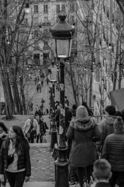 Paris, Fransa - 17 Şubat 2024: Montmartre Paris 'te Paris fenerleriyle birlikte Paris' in merdivenlerinde yürüyen turistlerin görüntüsü