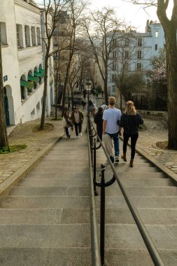 Paris, Fransa - 17 Şubat 2024: Montmartre Paris 'te Paris fenerleriyle birlikte Paris' in merdivenlerinde yürüyen turistlerin görüntüsü
