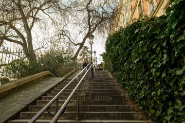 Paris, Fransa - 17 Şubat 2024: Montmartre Paris 'te Paris fenerleriyle birlikte Paris' in merdivenlerinde yürüyen turistlerin görüntüsü