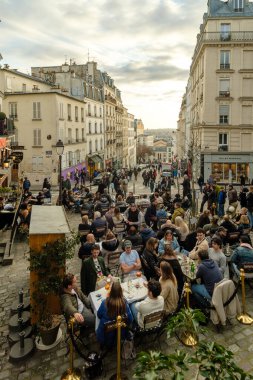 Paris, Fransa - 17 Şubat 2024: Paris 'te bir kafe restoranında insanların açık havada oturup akşam yemeği ve içkilerinin tadını çıkarması