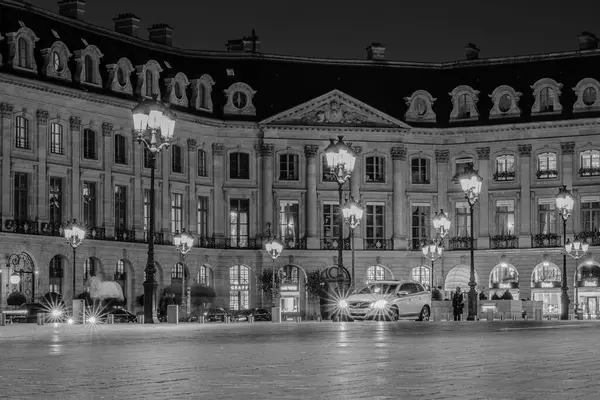 Paris, Fransa - 17 Şubat 2024: Paris 'teki lüks mağazaları ve otelleri ile birlikte işlek Place Vendme' deki aydınlanmış sokak lambalarının görüntüsü