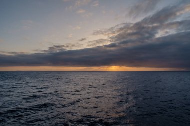 Bulutlu Ege Denizi 'nin panoramik manzarası ve altın bir gündoğumu