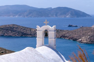 Yunanistan 'ın Ios adasındaki beyaz yıkanmış bir ortodoks şapelinin çatısından Ege Denizi' nin panoramik manzarası