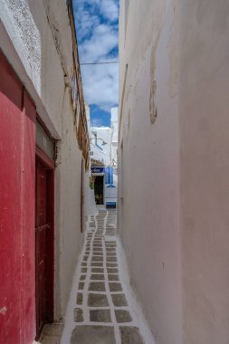 Ios, Yunanistan - 4 Mayıs 2024: Ios Yunanistan 'da pitoresk bir restorana giden tipik küçük bir ara sokağa bakmak